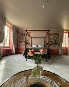 NazellesChâteau de la Huberdière的一间卧室配有床和花瓶