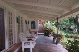 曼努埃尔安东尼奥Apartamento Karibu的门廊配有白色椅子、楼梯和植物