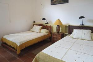 曼努埃尔安东尼奥Apartamento Karibu的一间卧室设有两张床和一张桌子上的台灯。
