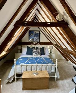 阿丁莱Chestnut Tree Cottage, 7 High Street的阁楼卧室配有蓝色床