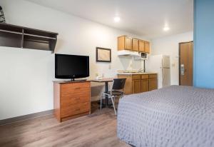 迈尔斯堡Extended Stay America Select Suites - Fort Myers的客房设有一张床、一张书桌和电视