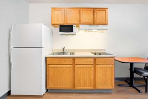 迈尔斯堡Extended Stay America Select Suites - Fort Myers - Northeast的厨房配有冰箱、水槽和桌子