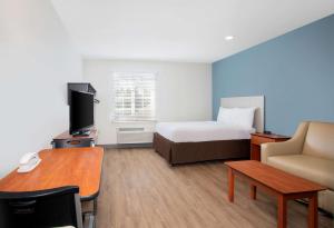 迈尔斯堡Extended Stay America Select Suites - Fort Myers - Northeast的配有一张床和一张书桌的酒店客房