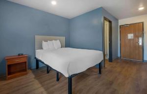 贝瑟默Extended Stay America Select Suites - Birmingham - Bessemer的蓝色卧室设有一张床和木地板