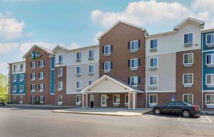 Portage LakesExtended Stay America Select Suites - Akron - South的一座大型砖砌建筑,停车场有停车位