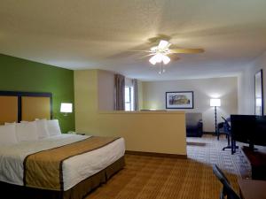 罗利Extended Stay America Suites - Raleigh - Midtown的酒店客房配有一张床和吊扇。