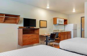 亚特兰大Extended Stay America Select Suites - Atlanta - Chamblee的酒店客房配有一张床和一张书桌及一台电视