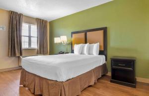 哥伦比亚Extended Stay America Select Suites - Columbia - Ft Jackson的一张大床,位于酒店带绿色墙壁的房间里