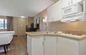 哥伦比亚Extended Stay America Select Suites - Columbia - Ft Jackson的一个带水槽的厨房和一张位于客房内的床