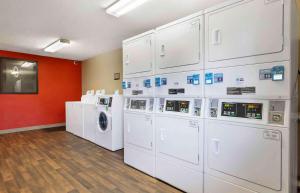 哥伦比亚Extended Stay America Select Suites - Columbia - Ft Jackson的洗衣房配有白色洗衣机和烘干机