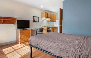 弗洛伦斯Extended Stay America Select Suites - Cincinnati - Florence - Airport的一间卧室配有一张床和一个小厨房