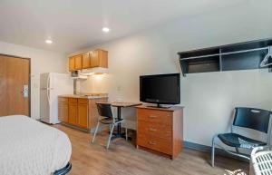 费舍尔Extended Stay America Select Suites - Indianapolis - Lawrence的一间带床和电视的房间以及一间厨房