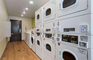 格尔夫波特Extended Stay America Select Suites - Gulfport的洗衣房配有白色洗衣机和烘干机