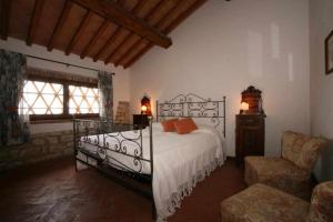 波吉奥的圣多纳托Agriturismo San Silvestro的一间卧室配有一张床、一张沙发和一把椅子