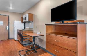 杰克逊维尔Extended Stay America Select Suites - Jacksonville - North的一间设有书桌和梳妆台电视的房间