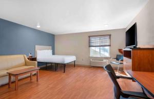 杰克逊维尔Extended Stay America Select Suites - Jacksonville - North的客厅配有沙发和1张床