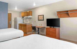 卡拉马祖Extended Stay America Select Suites - Kalamazoo - West的酒店客房设有两张床和带电视的厨房。