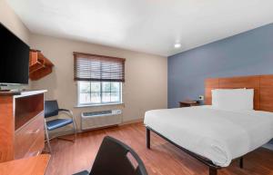 沃思湖Extended Stay America Select Suites - Lake Worth的一间卧室配有一张大床和电视