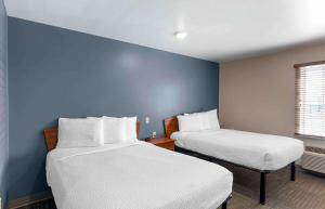 拉夫兰Extended Stay America Select Suites - Loveland的蓝色墙壁客房的两张床