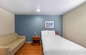 拉伯克Extended Stay America Select Suites - Lubbock - South的一间卧室配有一张大床和一张沙发