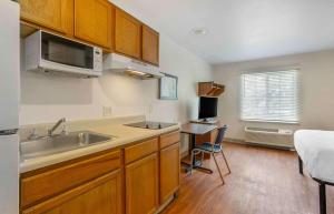 查尔斯顿Extended Stay America Select Suites - Charleston - North Charleston - I-526的一个带水槽的厨房和一张书桌