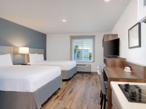 墨尔本Extended Stay America Select Suites - Melbourne - West Melbourne的酒店客房带两张床和厨房
