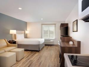 墨尔本Extended Stay America Select Suites - Melbourne - West Melbourne的酒店客房,配有床和沙发