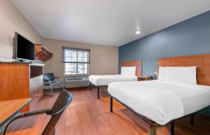 俄克拉何马城Extended Stay America Select Suites - Oklahoma City - West的酒店客房设有两张床和电视。