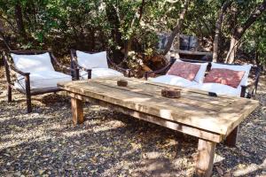 Lo BarnecheaIluminada casa de piedra entre bosque y río的一张木桌、两把椅子和长凳