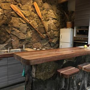 Lo BarnecheaIluminada casa de piedra entre bosque y río的厨房配有木桌和石墙