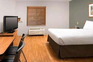 莱赫Extended Stay America Select Suites - Provo - American Fork的一间卧室配有一张床和一张带电脑的书桌