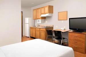 莱赫Extended Stay America Select Suites - Provo - American Fork的客房设有一张床和一间带书桌的厨房
