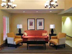 查尔斯顿美国延住公寓式酒店 - 查尔斯顿 - 机场的客厅配有红色的沙发和两把椅子