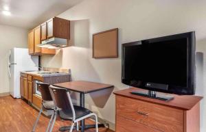什里夫波特Extended Stay America Select Suites - Shreveport - Airport的厨房配有小桌子和橱柜上的电视