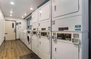 塔拉哈西Extended Stay America Select Suites - Tallahassee - Northwest的洗衣房配有白色橱柜、洗衣机和烘干机