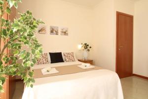 圣毛罗马尔Residence Altamarea的一间卧室配有床和植物