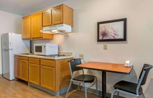 埃尔帕索Extended Stay America Select Suites - El Paso - East的一间带桌子和冰箱的小厨房