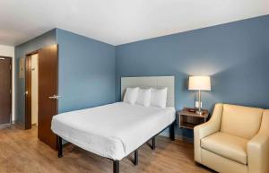 森特尼尔Extended Stay America Suites - Denver - Centennial的卧室配有白色的床和椅子