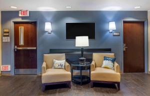 霍舍姆美国费城霍舍姆威尔士路长住酒店的一间设有两把椅子和一张桌子的等候室以及一台电视