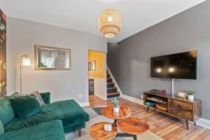 费城Trendy Fishtown Mid-Century Modern Inspired Home的客厅配有绿色沙发和平面电视