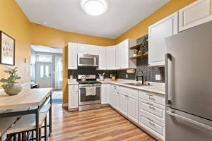 费城Trendy Fishtown Mid-Century Modern Inspired Home的厨房配有白色橱柜和不锈钢冰箱