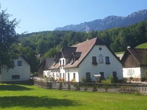 赖兴瑙Familie Stoier的白色的房子,有栅栏和山脉背景