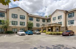 奥兰多Extended Stay America Select Suites - Orlando - Maitland - 1760 Pembrook Dr的停车场内停放汽车的大型建筑