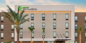 桑福德Extended Stay America Premier Suites - Orlando - Sanford的一座楼前有棕榈树的酒店