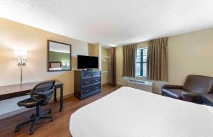 奥兰多Extended Stay America Select Suites - Orlando - Southpark - Equity Row的酒店客房,配有一张床、一张桌子和椅子