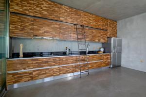 KoríthionStunning 180° Sea View Designer Villa for two的厨房配有木制橱柜和金属冰箱