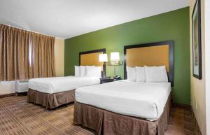 彭萨科拉美国 - 彭萨科拉 - 大学城长住旅馆的绿墙旅馆客房的两张床