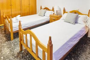 波多黎多德萨贡托EL RINCÓN VERDE的配有木柜的客房内的两张单人床