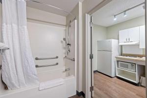 迈阿密美国长住酒店 - 迈阿密 - 机场 - 多拉尔的带淋浴的浴室和冰箱。