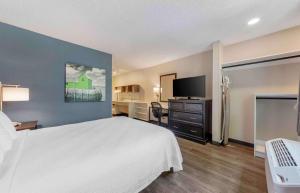 迈阿密Extended Stay America Premier Suites - Miami - Airport - Doral - 87th Avenue South的配有一张床和一台平面电视的酒店客房